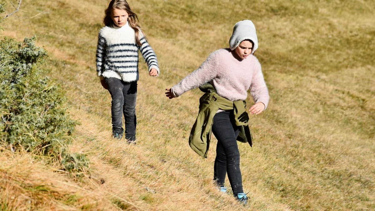 Two ladinian sisters walking slightly pissed  on the ancient pathway of Troi Pajan at Lech Dagustel in Val Gardena Gröden in Südtirol, Italy.